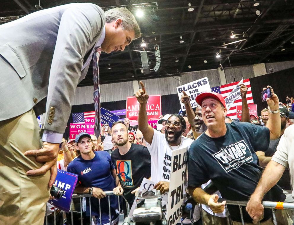 PHOTO: CNN chief white house correspondent Jim Acosta (left) deals with Trump supporters yelling "Fake News" at him while he goes live during a President Donald Trump's Make America Great Again Rally at the Florida State Fair Grounds in Tampa, Fla.
