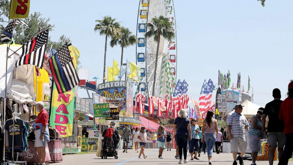 PHOTO: Visitors to the 2021 Florida State Fair tour a row of concessions and venders on opening day, April 22, 2021, at the Florida State Fairgrounds in Tampa, Fla.