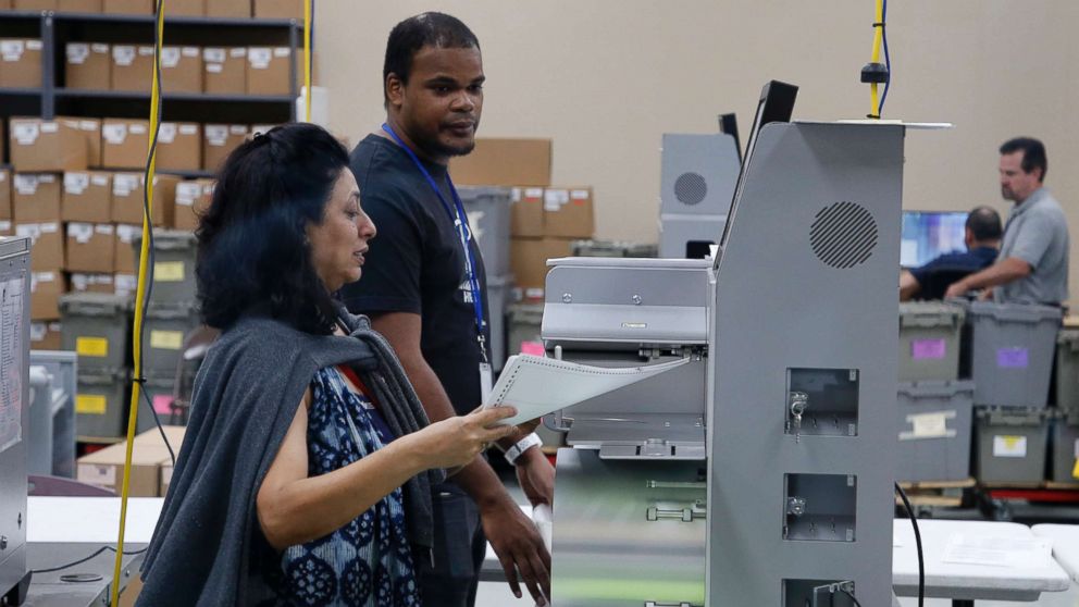 PHOTO: An elections worker feeds ballots into a tabulation machine at the Broward County Supervisor of Elections office on Nov. 10, 2018 in Lauderhill, Fla.