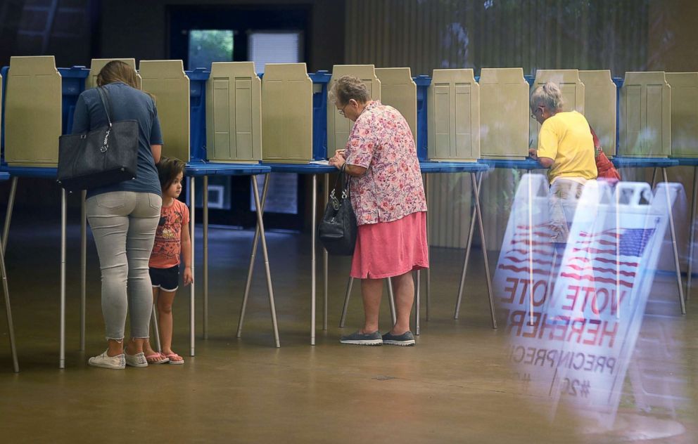 PHOTO: Fionna Beazzo stands with her mother Erin Beazzo as she fills out her primary day voting ballot next to Beverly Putzke at a polling station, Aug. 28, 2018, in St. Augustine, Fla.