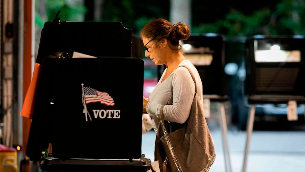 PHOTO: A woman casts her vote during the Florida primary election at Doris &  Phil Sanford Fire Rescue Station Coral Gables in Miami, on March 17, 2020.