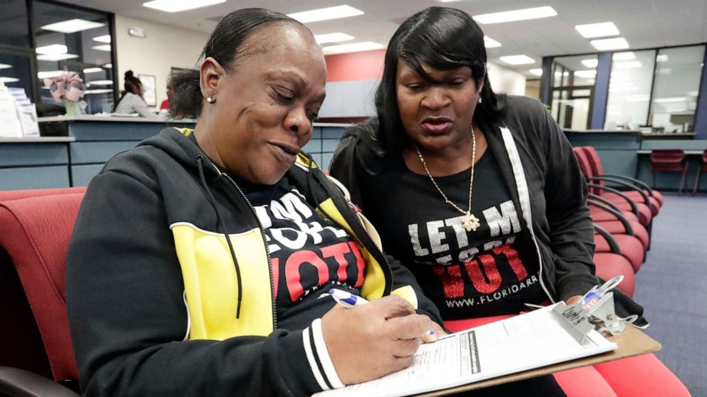 PHOTO: Former felon Yolanda Wilcox, left, fills out a voter registration form as her best friend Gale Buswell looks on at the Supervisor of Elections office Tuesday, Jan. 8, 2019, in Orlando, Fla.