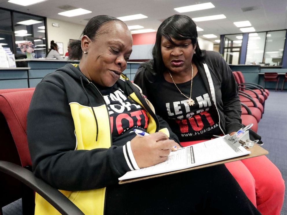 PHOTO: Former felon Yolanda Wilcox, left, fills out a voter registration form as her best friend Gale Buswell looks on at the Supervisor of Elections office Tuesday, Jan. 8, 2019, in Orlando, Fla.