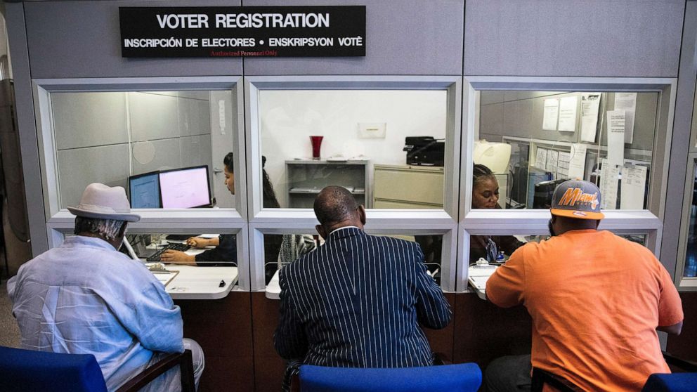 From left, Lorenzo Latson Sr., Clarence Office Jr. and Jerry Armstrong complete their voter registration at the Miami-Dade County Elections Department in Doral, Fla., Jan. 8, 2019.