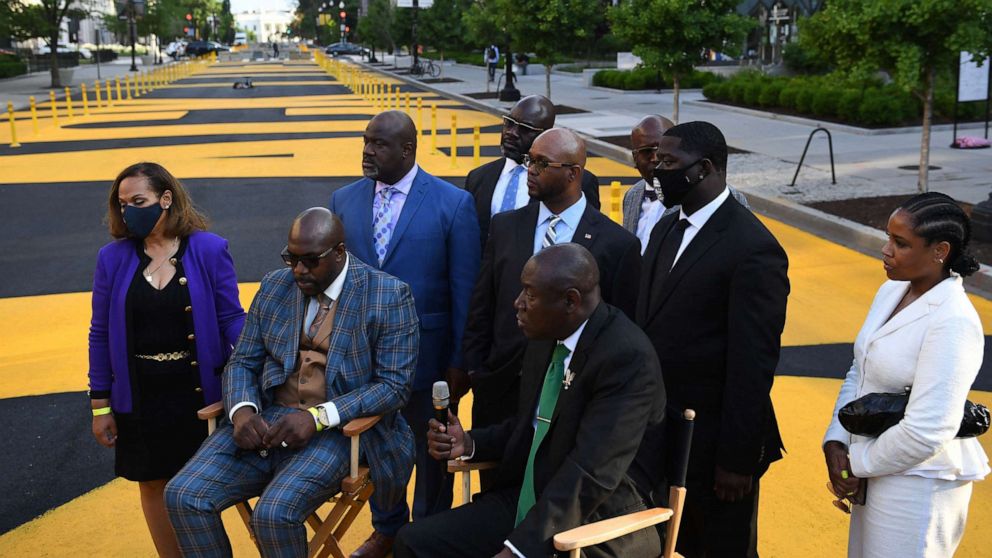 PHOTO: George Floyd's brother Philonise Floyd (2L) looks on as the family lawyer Ben Crump (2R) speaks to the media on Black Lives Matter plaza after a meeting at the White House with President Joe Biden in Washington, D.C., May 25, 2021. 