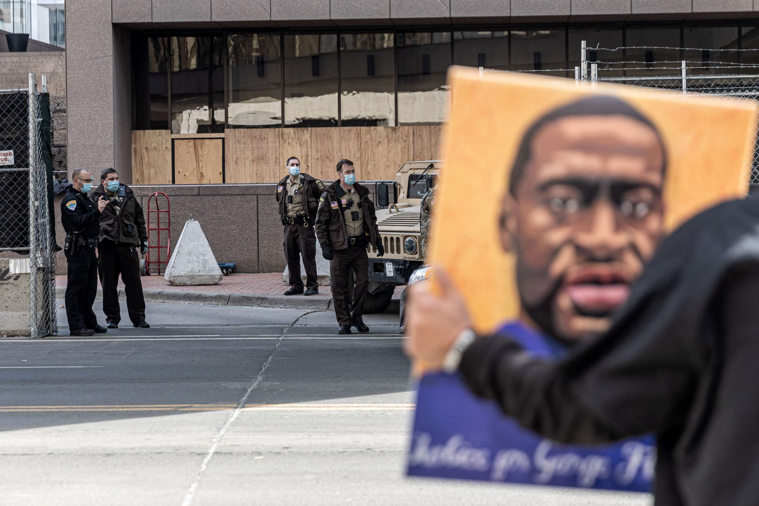 PHOTO: A demonstrator holds a portrait of George Floyd outside the Hennepin County Government Center, March 9, 2021, in Minneapolis, Minnesota.