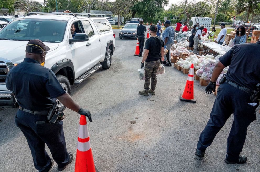 PHOTO: Volunteers from the Feeding South Florida food bank deliver bags of food to people in need at a drive-through in Opa-Locka, Fla., April 14, 2020.