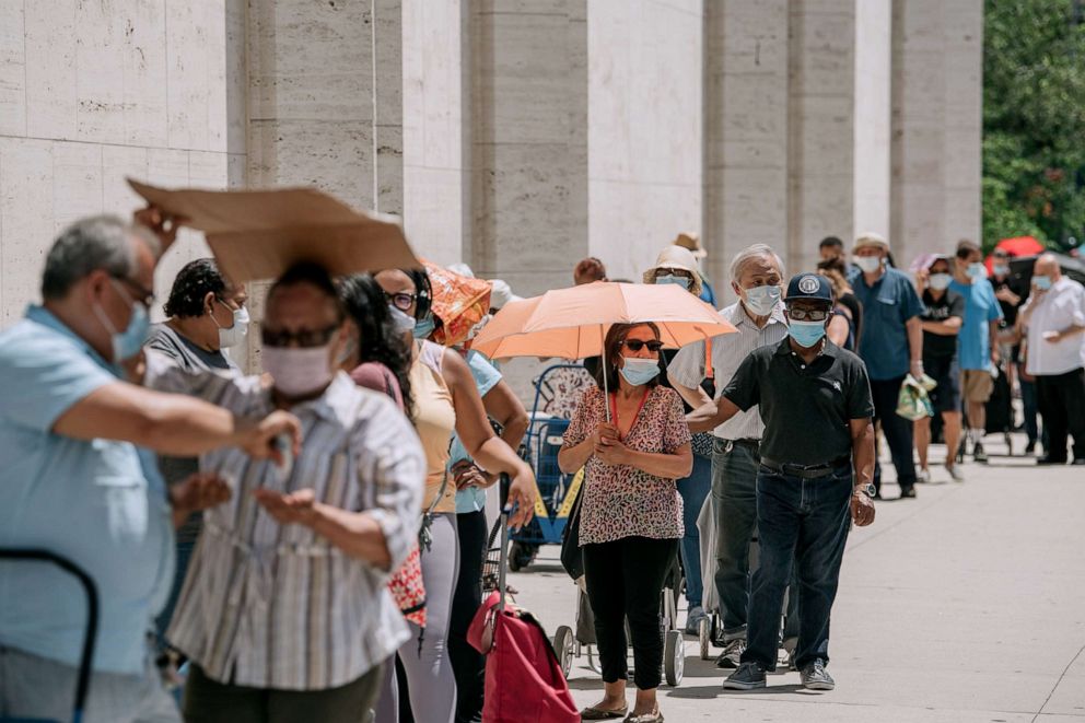PHOTO: New Yorkers in need wait in a long line to receive free produce, dry goods, and meat at a Food Bank For New York City distribution event at Lincoln Center on July 29, 2020, in New York.