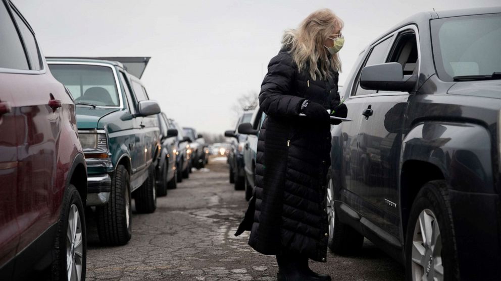 PHOTO: A volunteer from Forgotten Harvest food bank checks cars at a mobile food pantry before distributing goods ahead of Christmas amid the COVID-19 pandemic in Warren, Mich., Dec. 21, 2020.