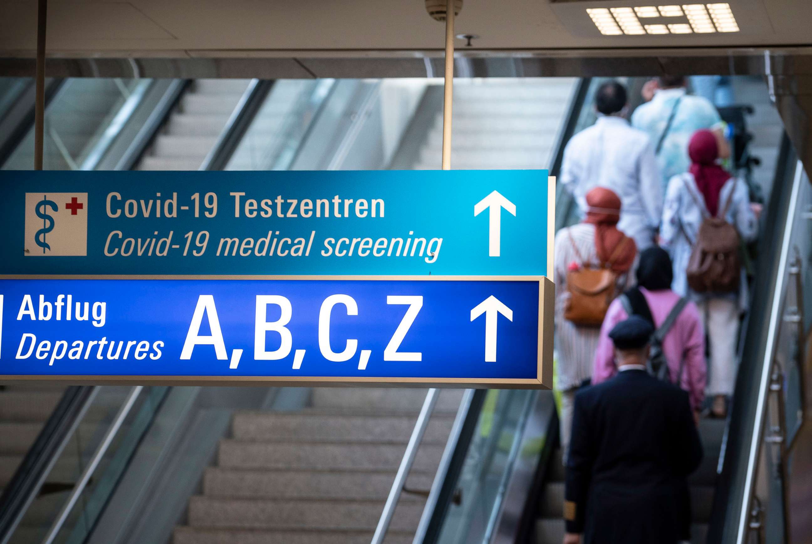 PHOTO: A sign in the arrivals area of Frankfurt Airport shows the way to departures and the Covid-19 test centers, Aug. 15, 2020.