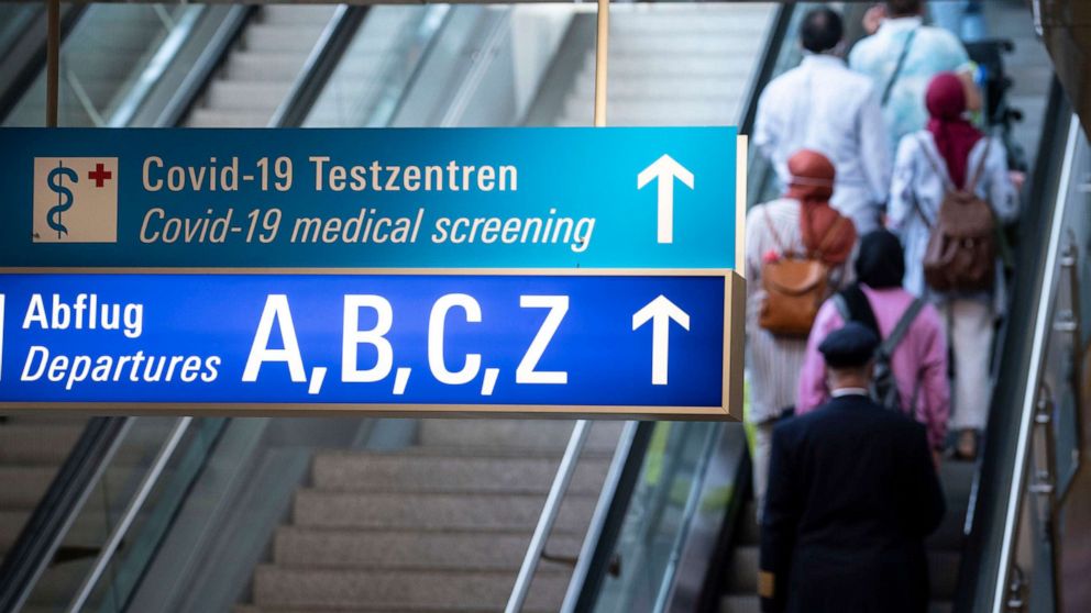 PHOTO: A sign in the arrivals area of Frankfurt Airport shows the way to departures and the Covid-19 test centers, Aug. 15, 2020.