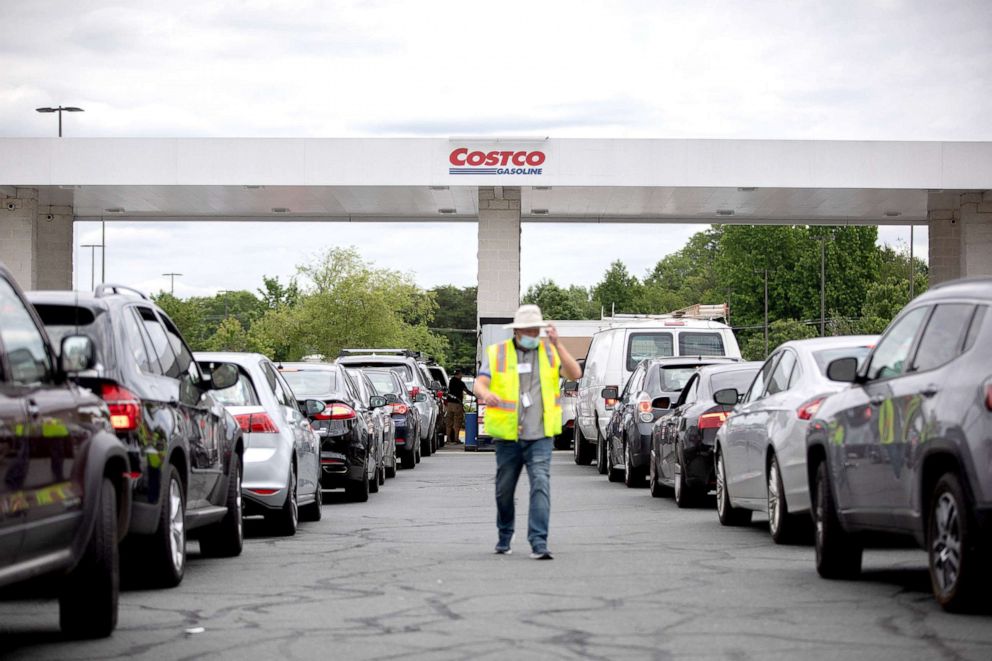PHOTO: Attendants direct cars as they line up to fill their gas tanks at a COSTCO in Charlotte, N.C., May 11, 2021. After a cyber attack caused the shutdown of the Colonial Pipeline, fears of gasoline shortage led to panic buying in several locations. 