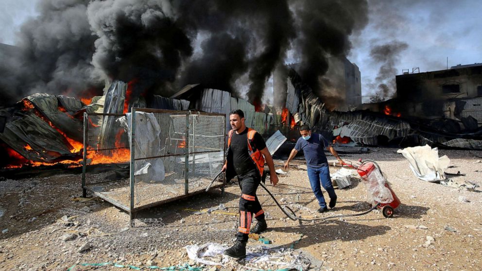 PHOTO: Palestinian firefighters douse a fire at a sponge factory after it was hit by Israeli artillery shells, according to witnesses, in the northern Gaza Strip, on May 17, 2021. 