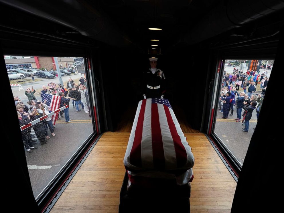 PHOTO: The flag-draped casket of former President George H.W. Bush passes through Magnolia, Texas, Dec. 6, 2018, along the train route from Spring to College Station, Texas.
