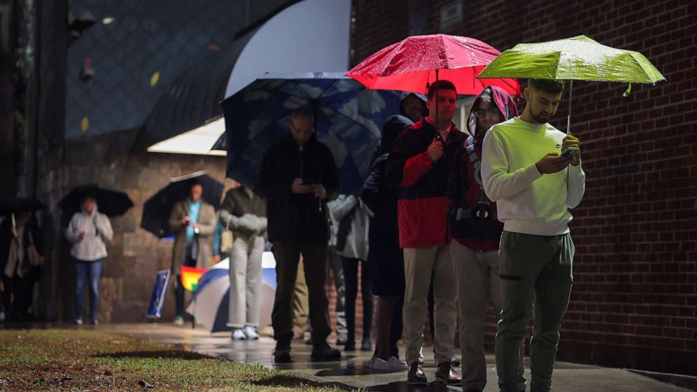 PHOTO: Local residents wait in line to cast their ballot during the runoff U.S. Senate election between Democratic Senator Raphael Warnock and his Republican challenger Herschel Walker in Atlanta, on Dec. 6, 2022.