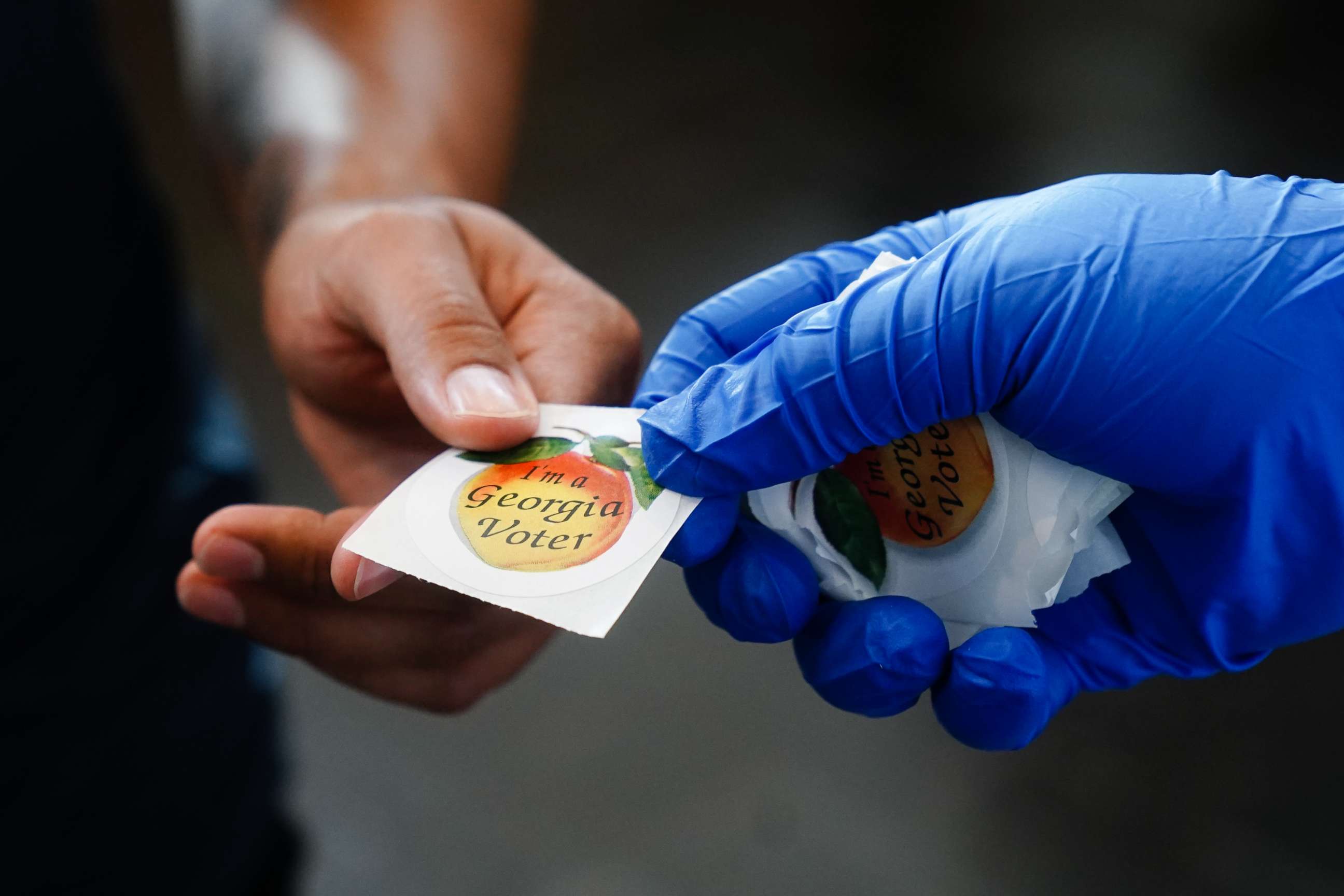 PHOTO: A man receives an "I'm a Georgia Voter" sticker after casting a ballot in Georgia's Primary Election, June 9, 2020, in Atlanta.