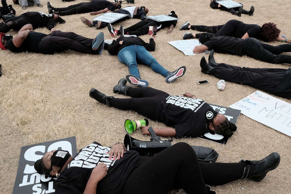 PHOTO: People stage a die-in outside of the World Of Coca-Cola museum in Atlanta, March 15, 2021, protesting the Coca-Cola corporation's donations to politicians who are in support of bills that are an attempt at voter suppression, according to advocates.