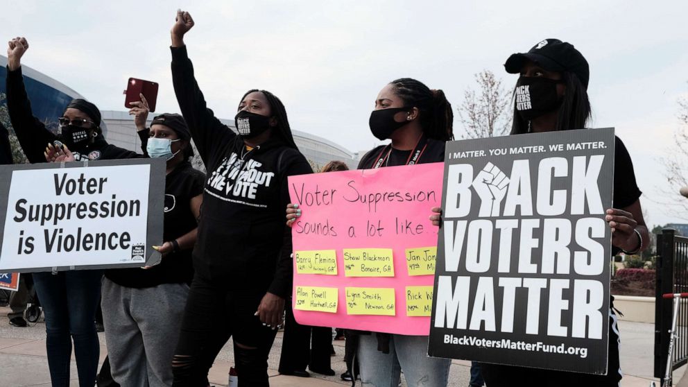 PHOTO: People hold a rally outside of the World Of Coca-Cola museum in Atlanta, March 15, 2021, protesting the Coca-Cola corporation's donations to several politicians who are in support of bills that advocates believe are an attempt at voter suppression.