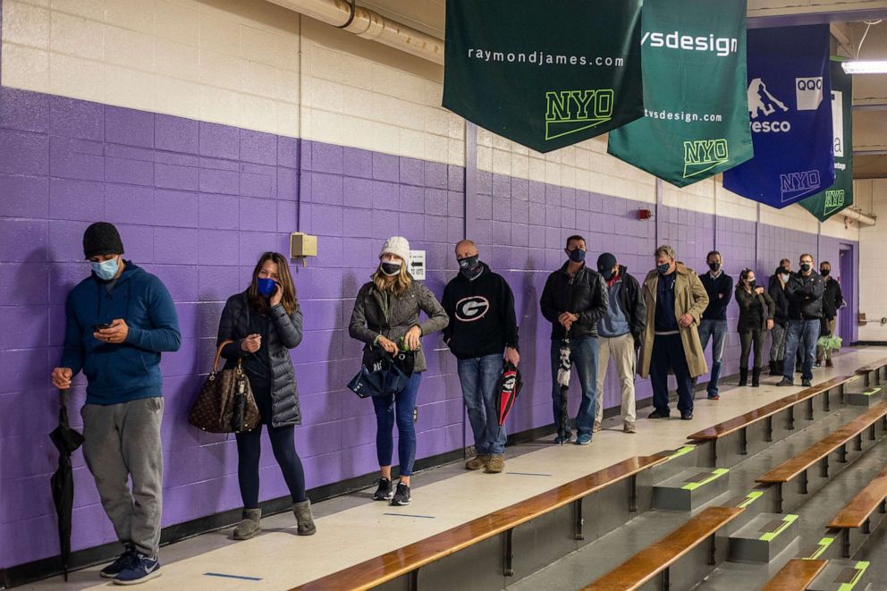 PHOTO: Fulton County voters stand in line to participate in early voting in the state's runoff election at Chastain Park Gymnasium in Atlanta's Chastain Park neighborhood, Dec. 16, 2020.
