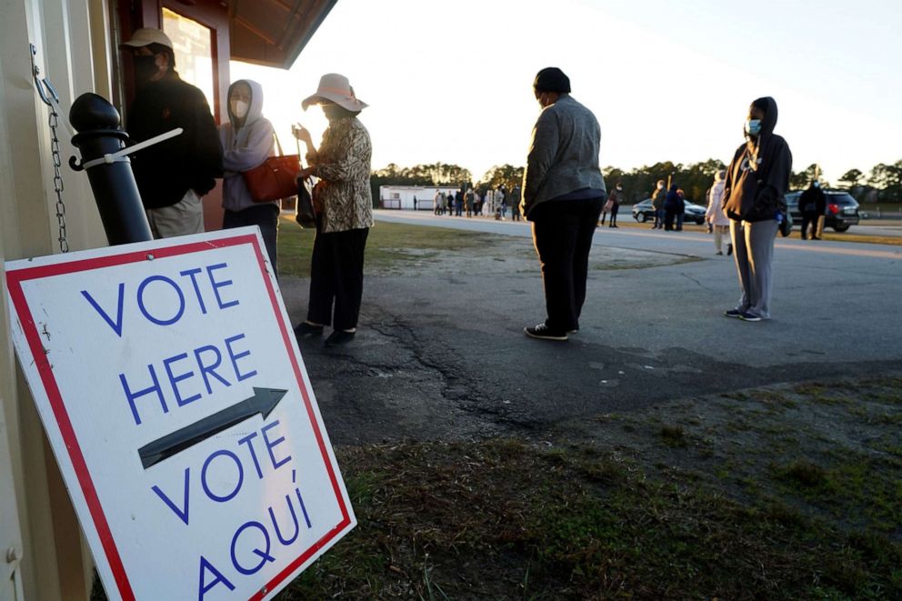 PHOTO: Voters stand in line to cast their ballots during the first day of early voting in the US Senate runoff at the Gwinnett Fairgrounds, Dec. 14, 2020, in Atlanta.