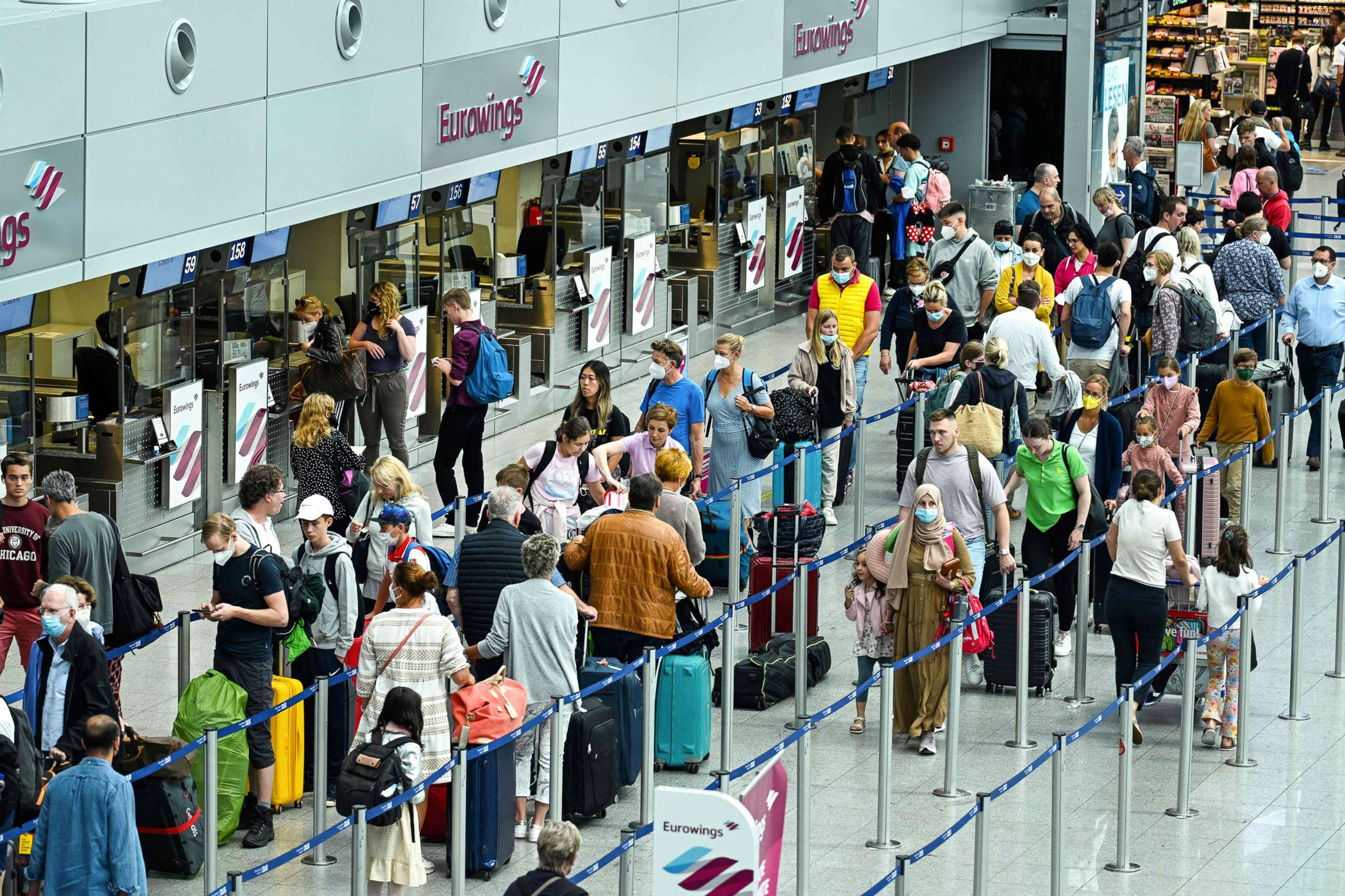 PHOTO: Passengers queue at the check-in counter of airline Eurowings, a subsidiary of the Lufthansa Group, at Duesseldorf International Airport (DUS), western Germany, on July 1, 2022.
