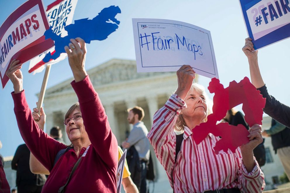 PHOTO: Shirley Connuck, right, of Falls Church, Va., holds up a sign representing a district in Texas, as the Supreme Court hears a case on possible partisan gerrymandering by state legislatures Oct. 3, 2017, in Washington, D.C.