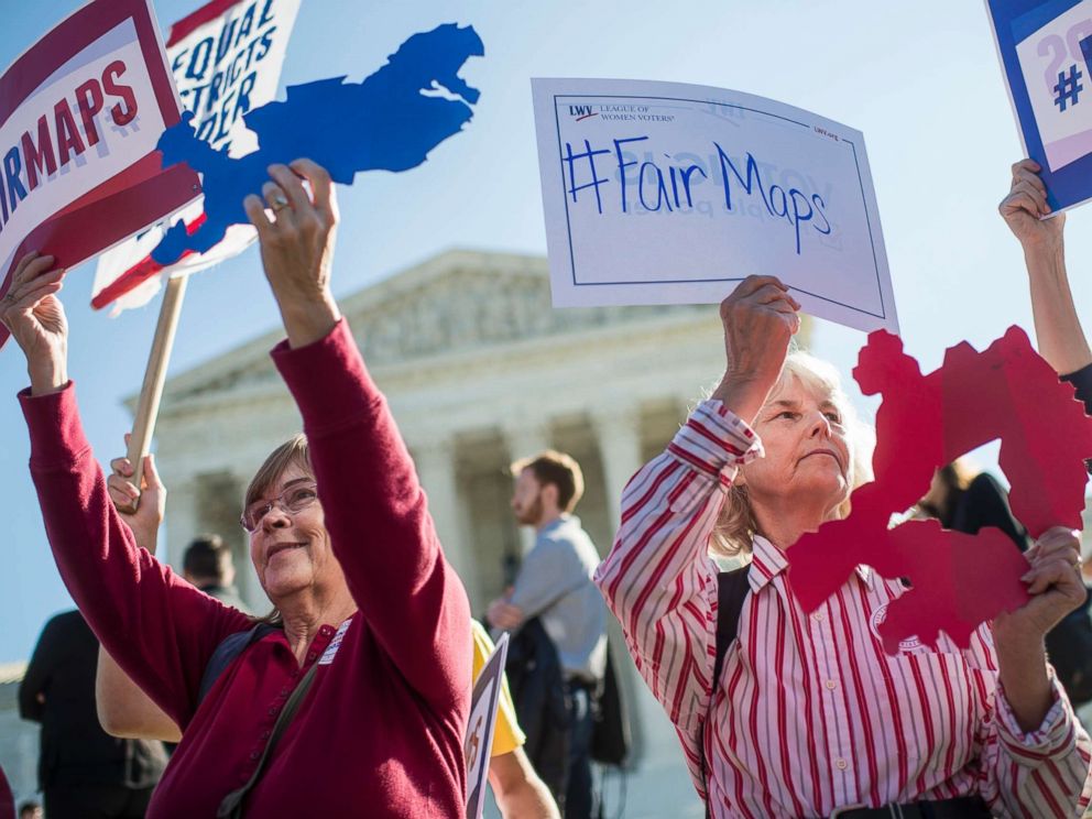 PHOTO: Shirley Connuck, right, of Falls Church, Va., holds up a sign representing a district in Texas, as the Supreme Court hears a case on possible partisan gerrymandering by state legislatures Oct. 3, 2017, in Washington, D.C.