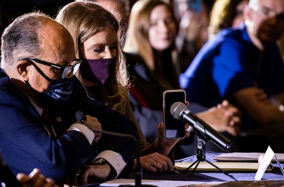 PHOTO: Jenna Ellis, a member of President Donald Trump's legal team, holds a cellphone to a microphone so the president can speak to Pennsylvania Republican lawmakers gathered at the Wyndham Gettysburg Hotel on Nov. 25, 2020 to discuss election issues.