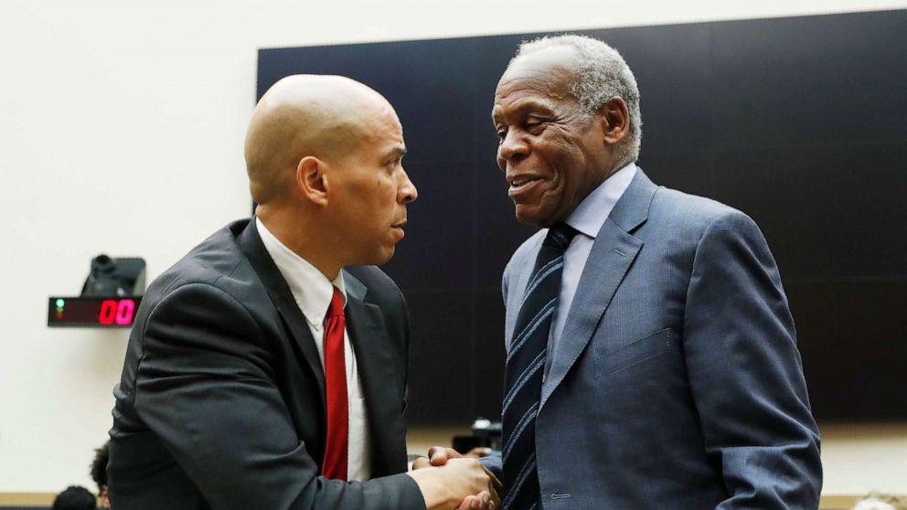 PHOTO: Sen. Cory Booker, left, greets Danny Glover, before they testify about reparations for the descendants of slaves, during a hearing before the House Judiciary Subcommittee in Washington, June 19, 2019.
