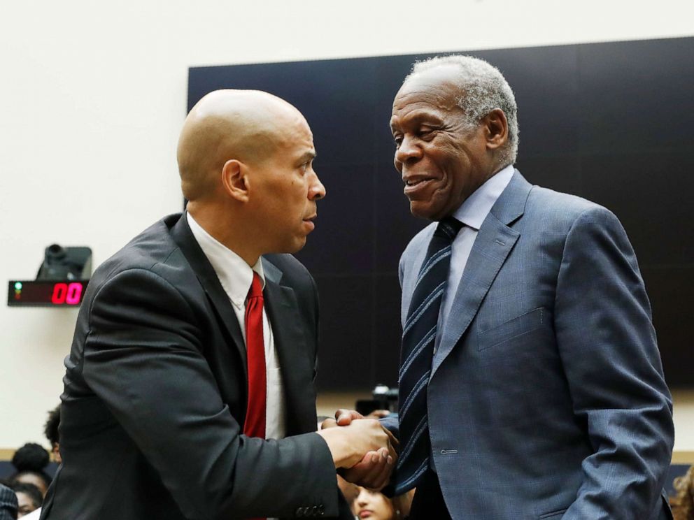 PHOTO: Sen. Cory Booker, left, greets Danny Glover, before they testify about reparations for the descendants of slaves, during a hearing before the House Judiciary Subcommittee in Washington, June 19, 2019.
