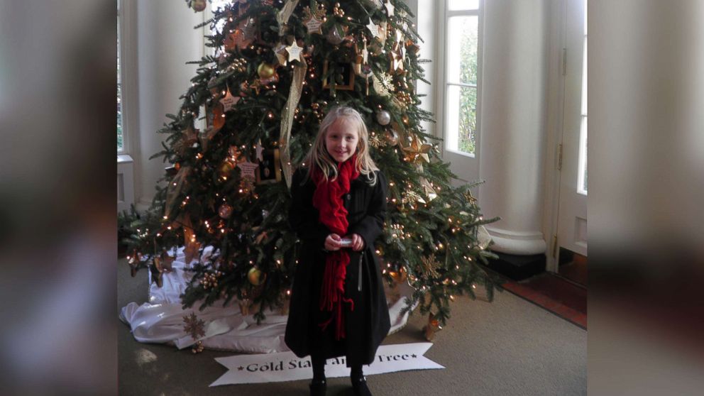 PHOTO: Grace Booth, daughter of 1st Lt. Joshua L. Booth, stands in front of the Gold Star Family Christmas tree at the White House in December 2011. 