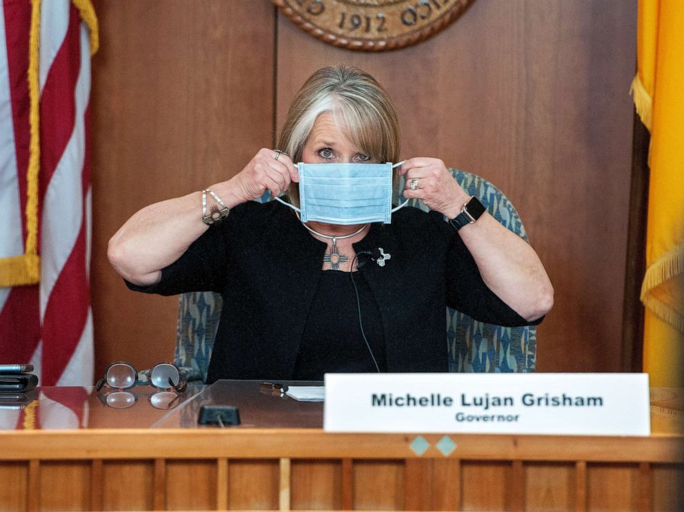 PHOTO: In this April 15, 2020, file photo, New Mexico Gov. Michelle Lujan Grisham puts on her face mask when not speaking during an update on the COVID-19 outbreak in the state during a news conference in the state Capitol in Santa Fe, N.M. 