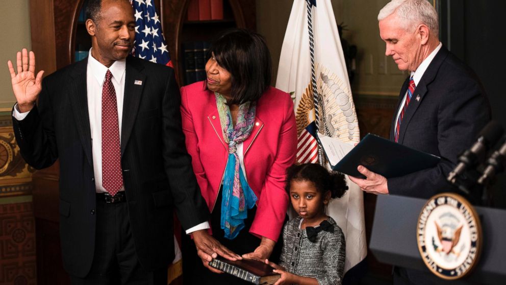 Ben Carson (L) is sworn in as US Secretary of Housing and Urban Development by Vice President Mike Pence (R) as his wife Candy Carson (2L) and granddaughter Tesora Carson watch during a ceremony in the Eisenhower Executive Office Building, March 2, 2017. in Washington, D.C.