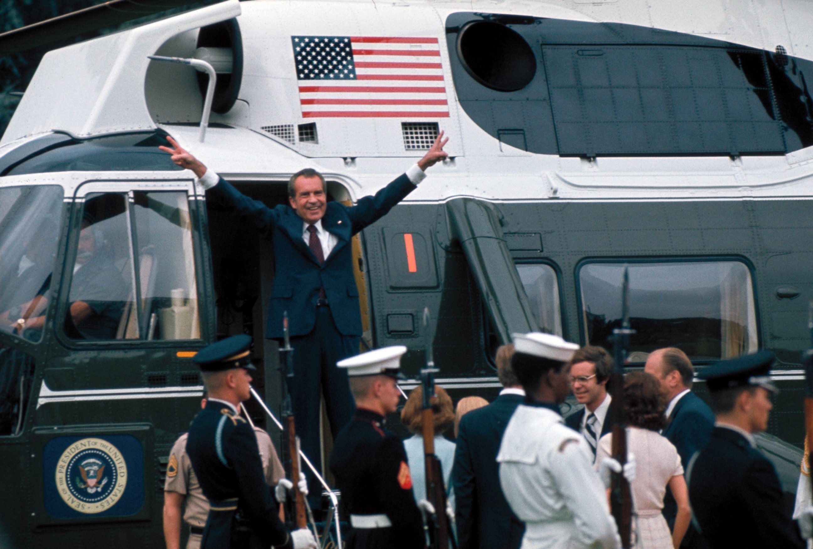 PHOTO: President Richard Nixon raises his hands with his trademark "V" sign in the doorway of a helicopter after leaving the White House following his resignation over the Watergate scandal, Aug. 9, 1974. 
