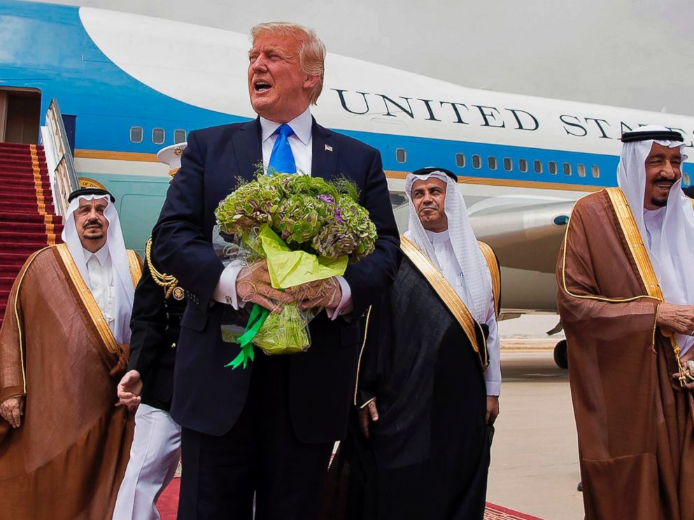 PHOTO: President Donald Trump holds a bouquet of flowers upon being welcomed by Saudi King Salman bin Abdulaziz al-Saud during his arrival at the airport in Riyadh on May 20, 2017.