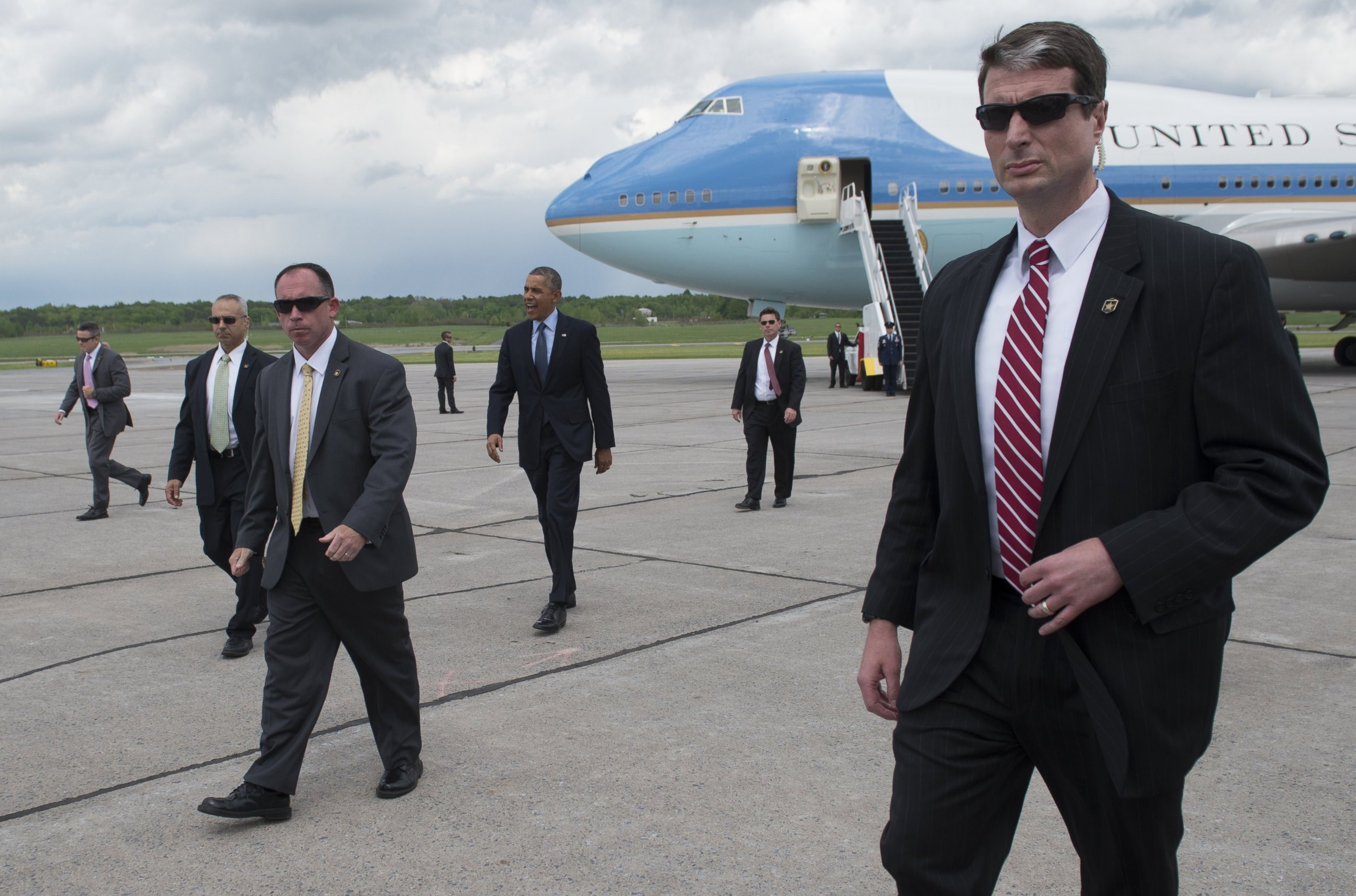 PHOTO: President Barack Obama, surrounded by US Secret Service agents, walks to greet guests after arriving on Air Force One at Griffiss International Airport in Rome, New York on May 22, 2014. 