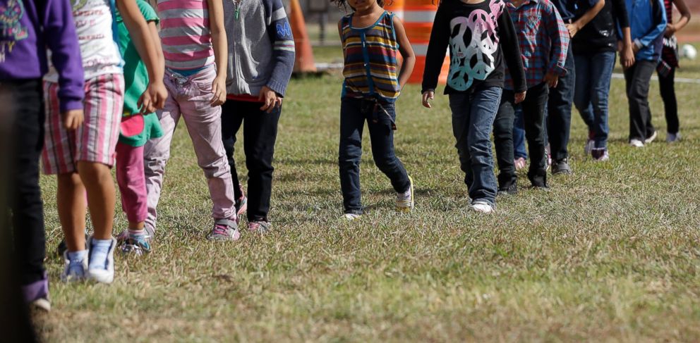 PHOTO: Detainees walk in a line at a U.S. Customs and Border Protection processing facility, on June 18, 2014, in Brownsville, Texas.