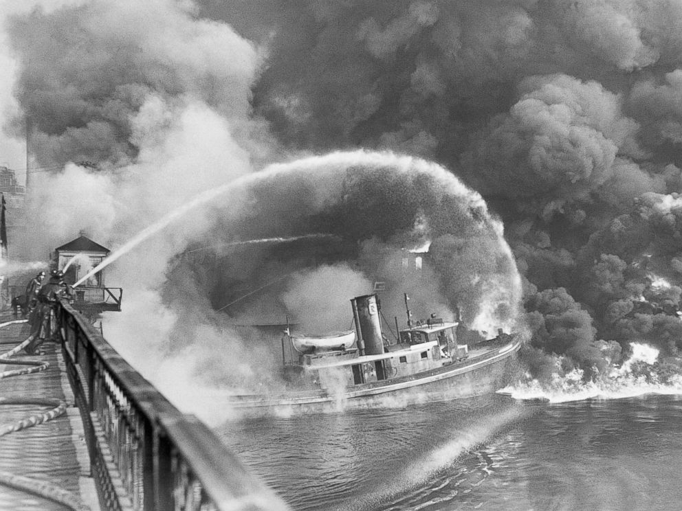 PHOTO: Firemen stand on a bridge over the Cuyahoga River to spray water on a tugboat as a fire burns an oil slick on the river, Nov. 3, 1952.
<p itemprop=