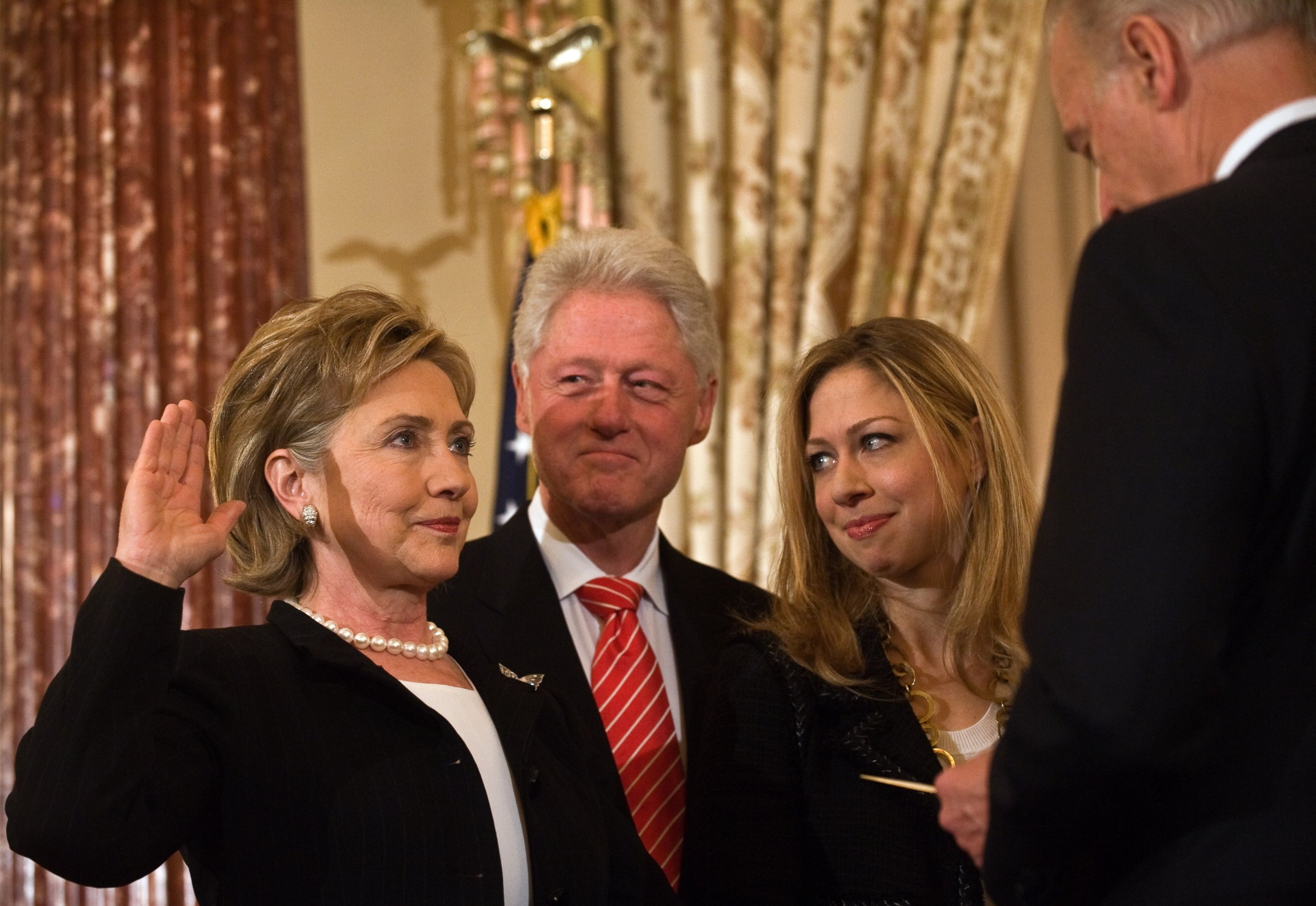 PHOTO: US Secretary of State Hillary Clinton is ceremonially sworn in by Vice President Joe Biden as her husband former president Bill Clinton and daughter Chelsea look on at the State Department in Washington, Feb. 2, 2009.    