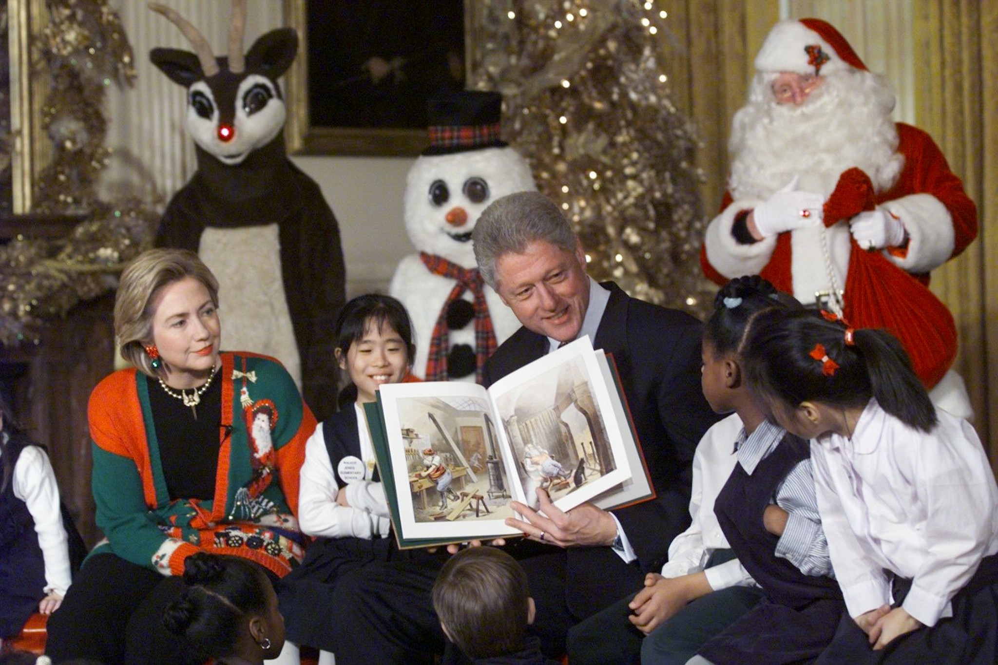 PHOTO: Bill Clinton (R) and Hillary Clinton (L) read 'Twas the Night Before Christmas' to a group of 60 children from 13 DC Schools in the East Room of the White House, Dec. 22, 1998.