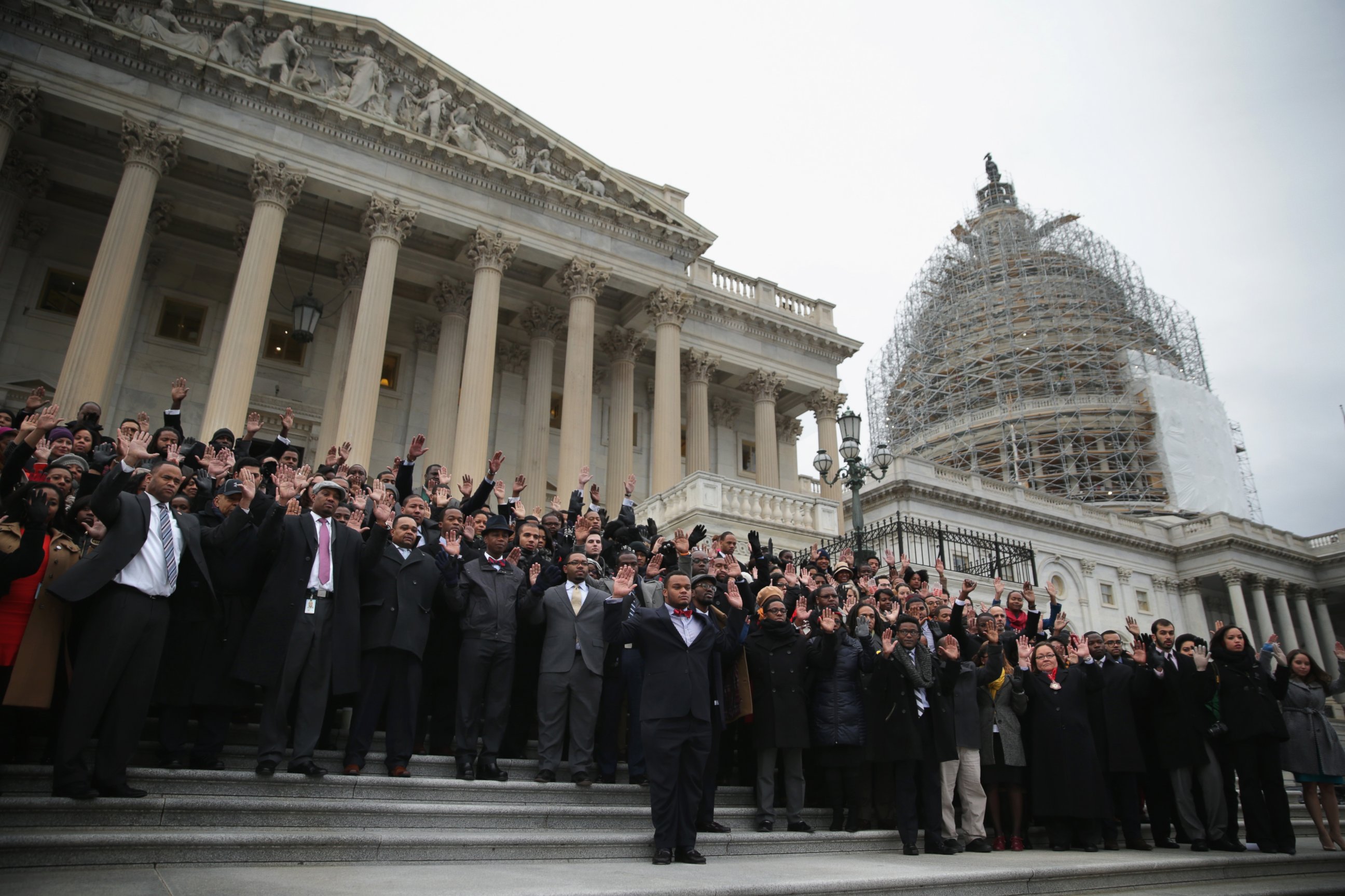 PHOTO: Black congressional staffers hold their hands up during a walkout to protest the recent Mike Brown and Eric Garner grand jury decisions on Dec. 11, 2014 on the steps of the U.S. Capitol in Washington, DC. 
