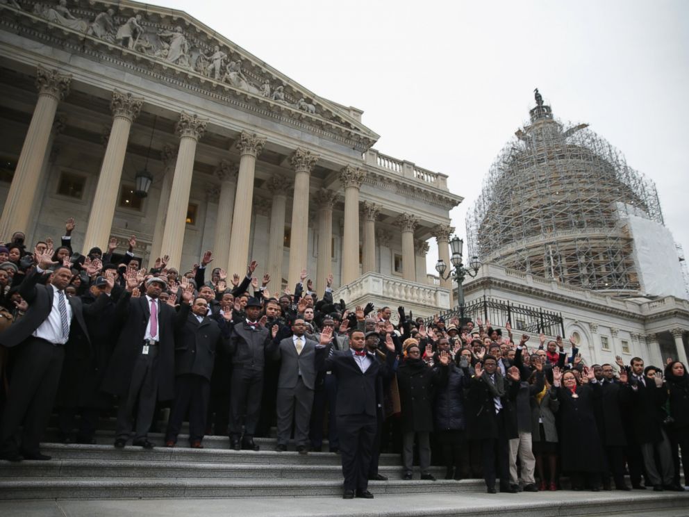 PHOTO: Black congressional staffers hold their hands up during a walkout to protest the recent Mike Brown and Eric Garner grand jury decisions on Dec. 11, 2014 on the steps of the U.S. Capitol in Washington, DC.
