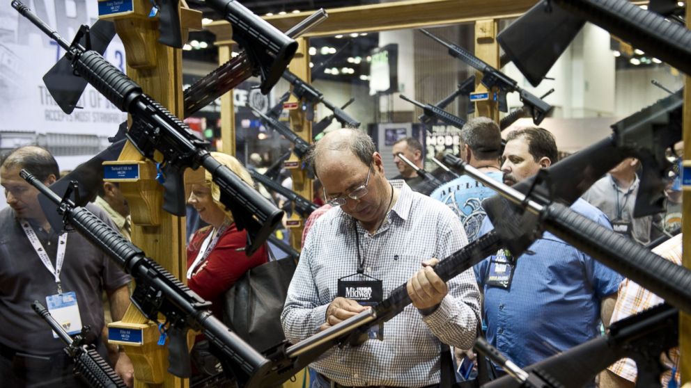 PHOTO: A convention goer examines weapons in the exhibit hall at the143rd NRA Annual Meetings and Exhibits at the Indiana Convention Center in Indianapolis, Indiana, on April 26, 2014.