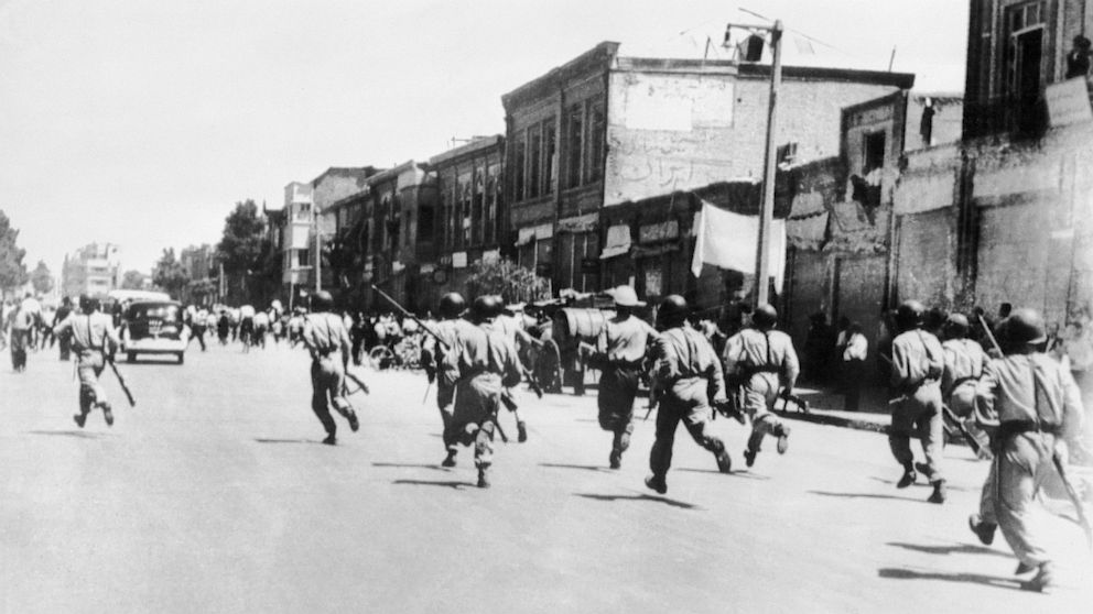 Persian soldiers chase rioters during civil unrest in Tehran, Aug. 1953.