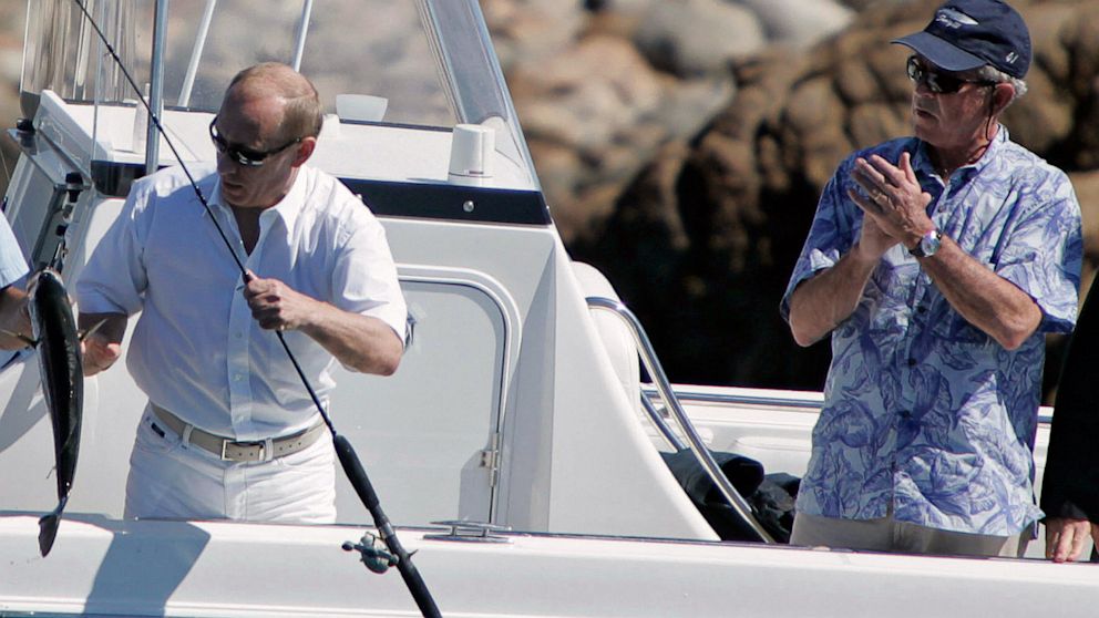 President George W. Bush (R) applauds as Russian President Vladimir Putin (L) catches a striped bass on July 2, 2007 while fishing in the Atlantic Ocean off of the Bush family compound in Kennebunkport, Maine.