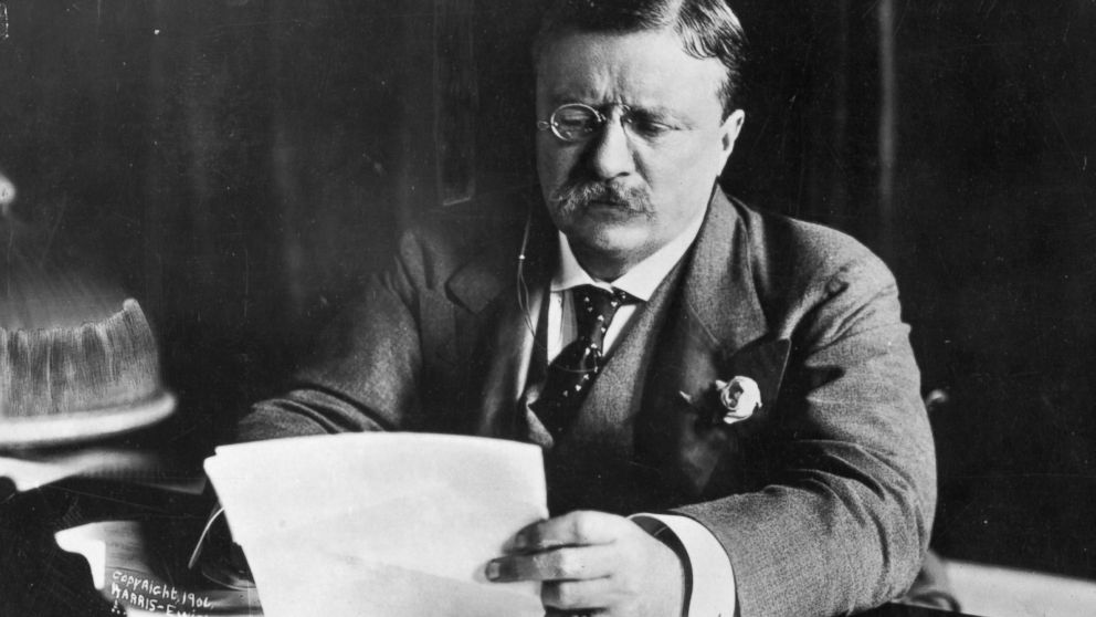 Theodore Roosevelt, the 26th President of the United States, sitting at his desk working.