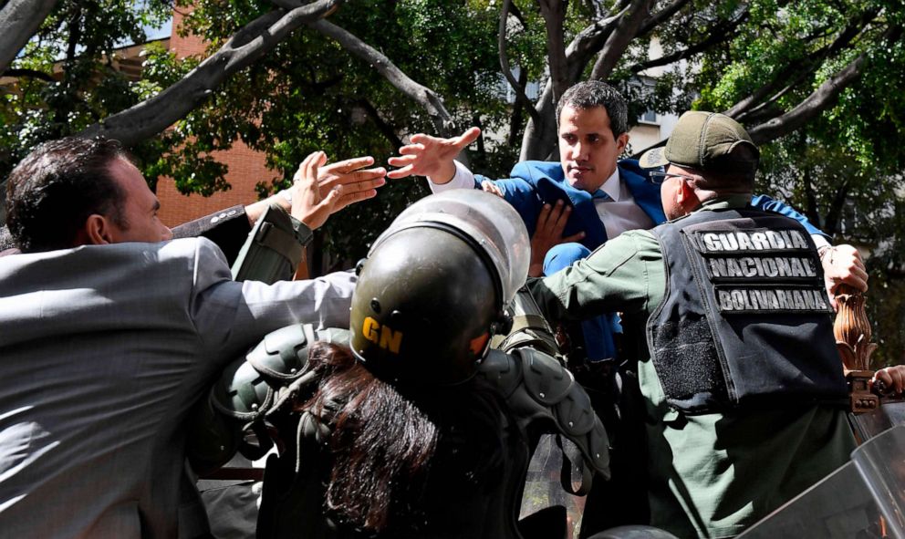 PHOTO: Venezuelan opposition leader Juan Guaido is blocked by security forces as he tries to reach the National Assembly building in Caracas by climbing over a fence, on Jan. 5, 2020.