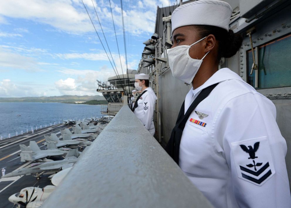 Aviation Machinist's Mate 2nd Class Sheila Ferreira, from New Bedford, Mass., mans the rails as the aircraft carrier USS Theodore Roosevelt  departs Naval Base Guam, June 4, 2020.