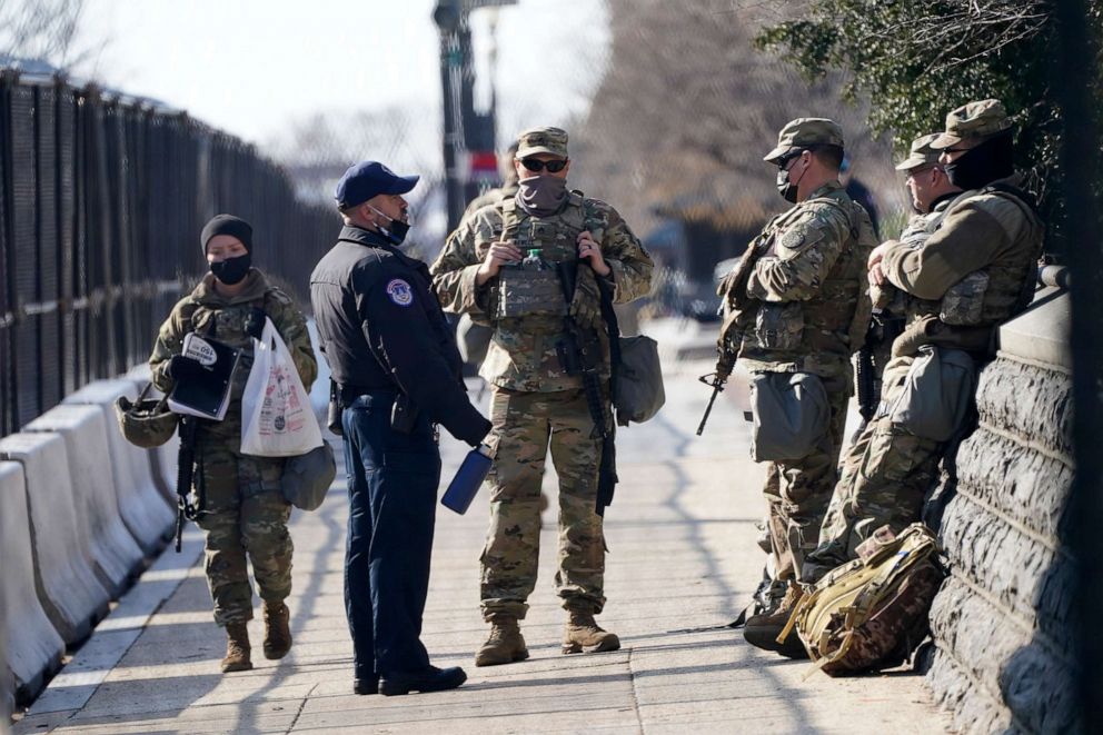 PHOTO: National Guard talk with a U.S. Capitol Police officer outside the Capitol building, March 4, 2021, in Washington, D.C.