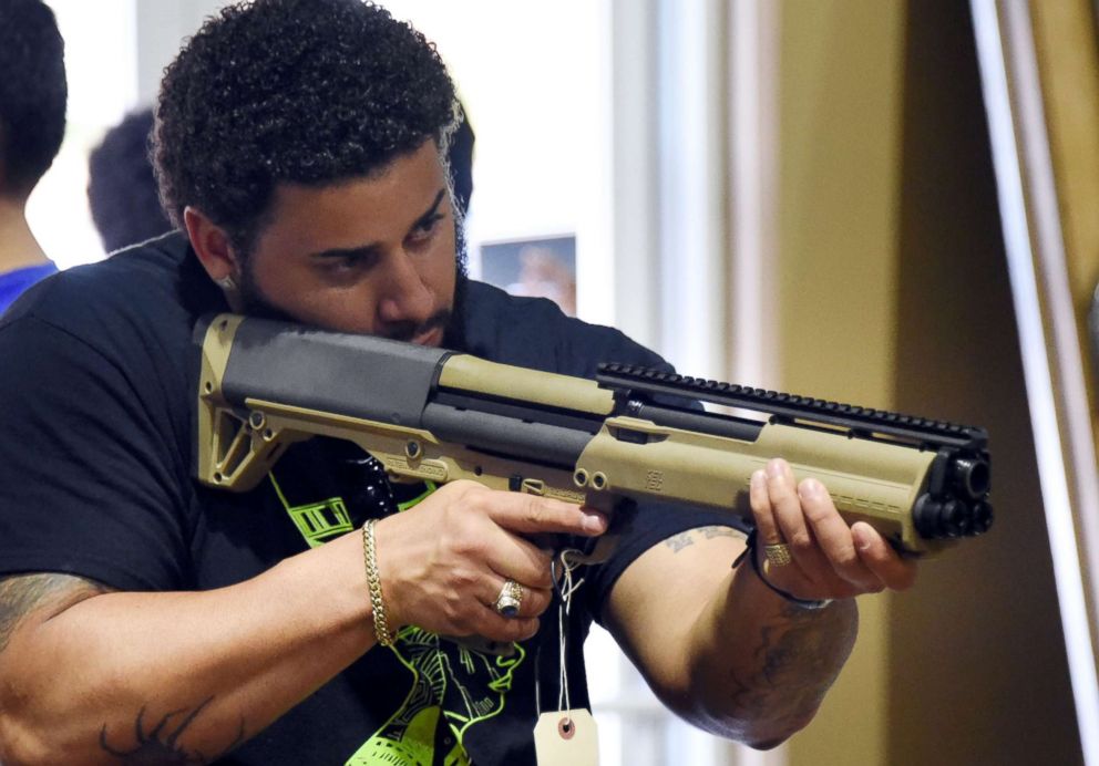 PHOTO: A gun enthusiast checks a weapon at the South Florida Gun Show at Dade County Youth Fairgrounds in Miami, Feb. 17, 2018.